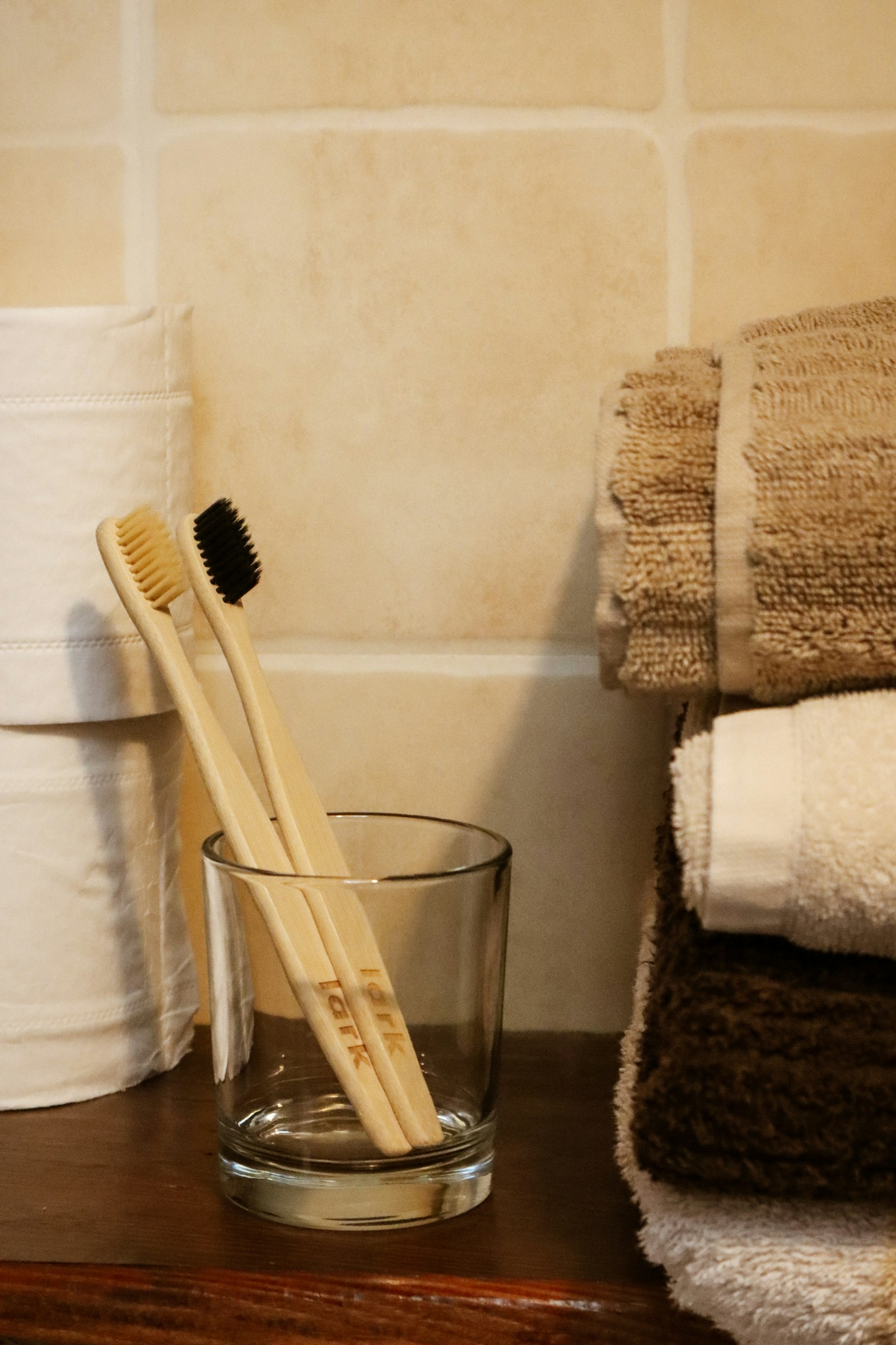 Dos cepillos de dientes de madera en un vaso sobre la mesa