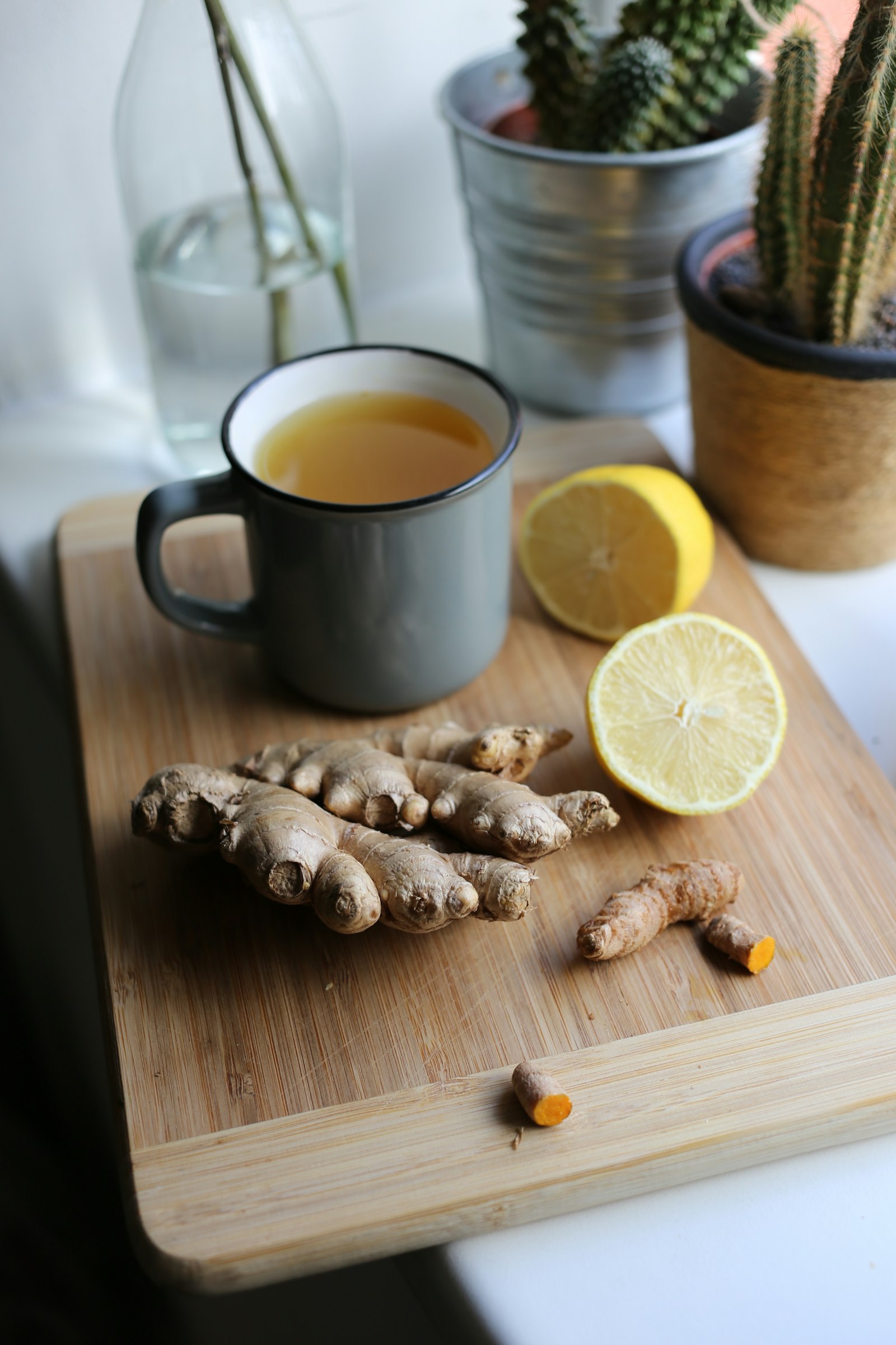 Tabla de cortar con limón en rodajas y jengibre fresco