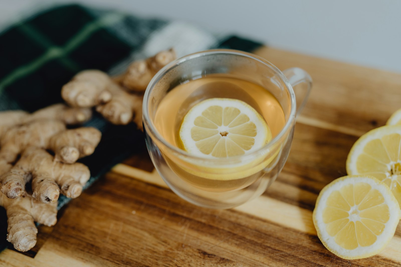 Taza de té con limón y jengibre sobre tabla de cortar