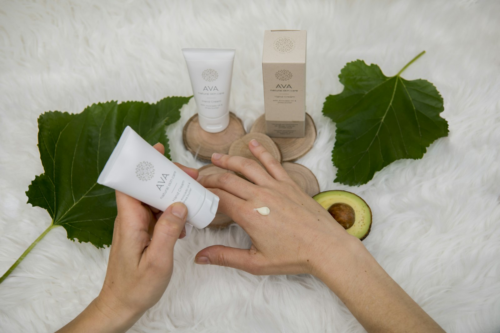 Mano sosteniendo un tubo de crema con luz natural cálida