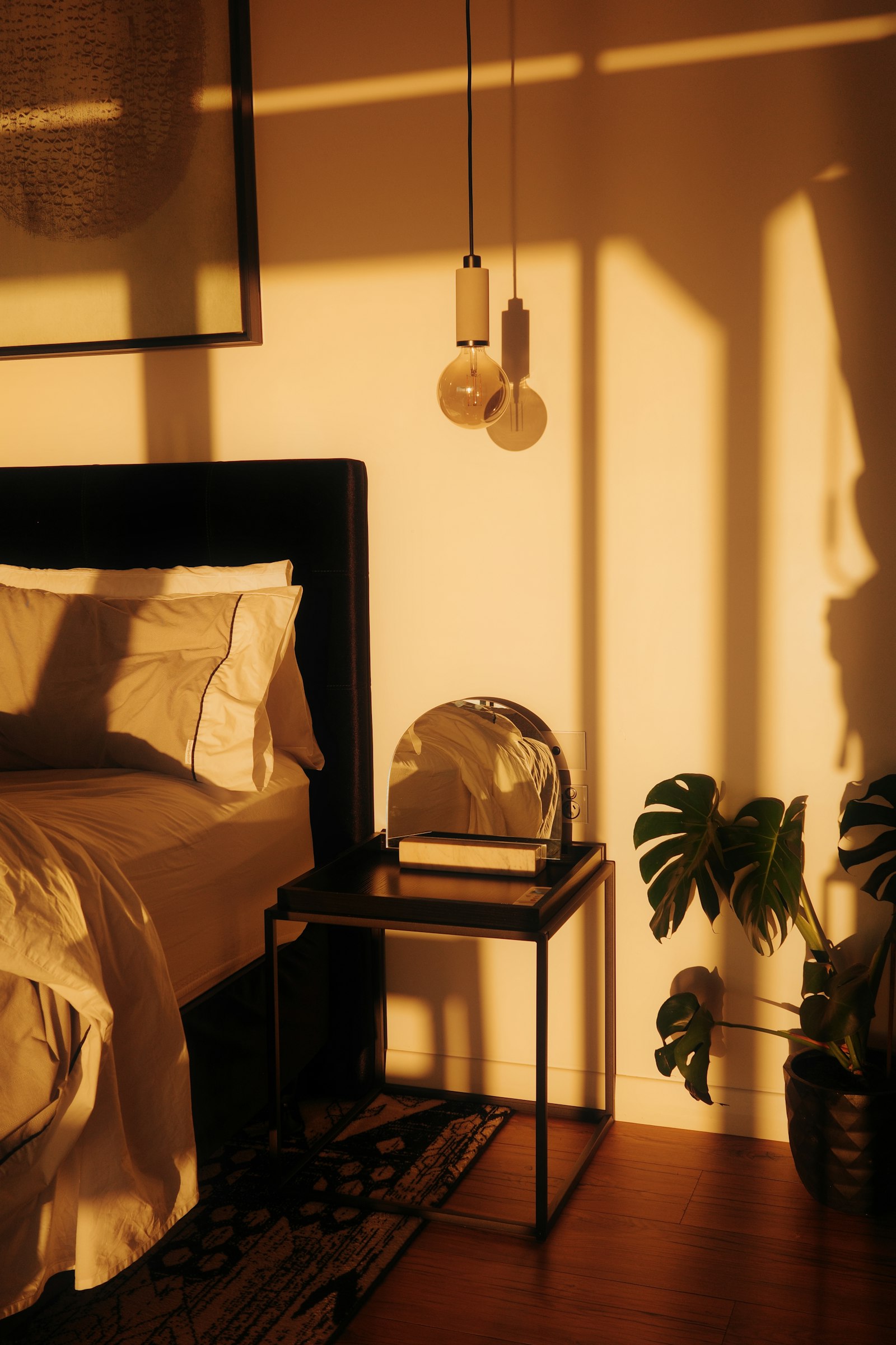 Luz cálida iluminando un dormitorio con cama y planta